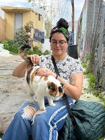 Nicole with a cat in a historic neighborhood